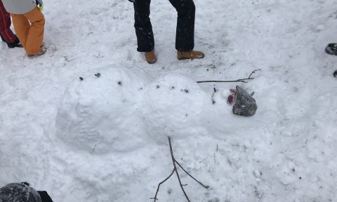 Ein liegender Schneemann mit Sonnenbrille